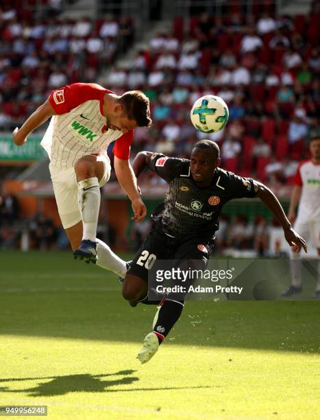 Rani Khedira of Augsburg and Anthony Ujah of Mainz head for the ball during the Bundesliga match between FC Augsburg and 1. FSV Mainz 05 at WWK-Arena...