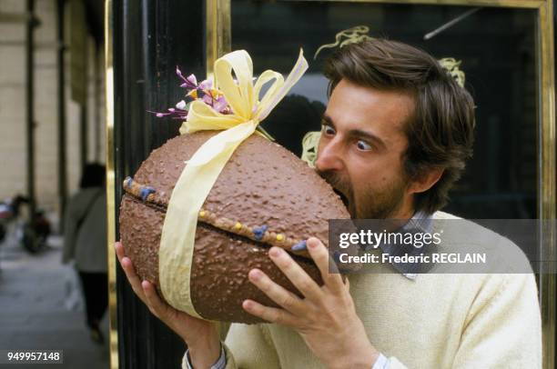 Portrait du réalisateur Nanni Moretti entrain de croquer un oeuf en chocolat le 2 avril 1986 à Paris, France.