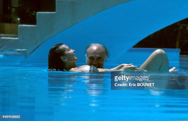 Michel Piccoli et son épouse Ludivine se baignent dans une piscine lors du tournage du film 'Adieu Bonaparte' en juillet 1984 en Egypte.