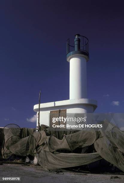 Filets de pêcheurs et phare dans un village sur l'étang de Thau en mai 1985 en France.