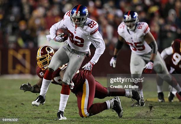 Mario Manningham of the New York Giants runs after a catch in front of London Fletcher of the Washington Redskins in the second quarter at FedEx...