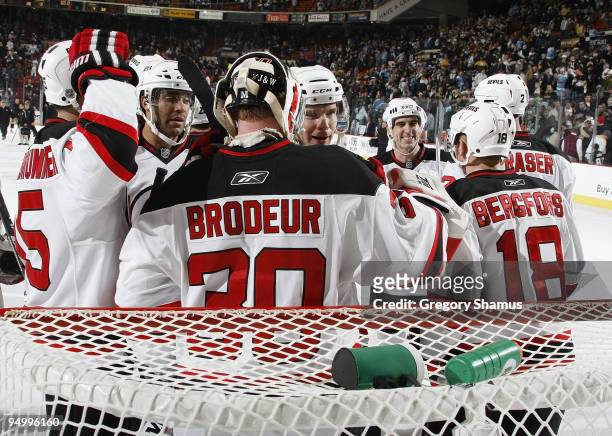 Martin Brodeur of the New Jersey Devils celebrates his 104th career shutout with teammates against the Pittsburgh Penguins on December 21, 2009 at...