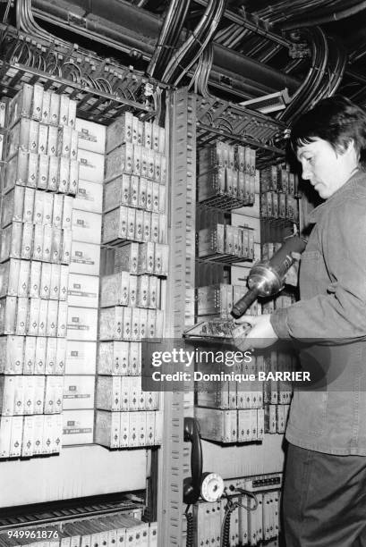 Un technicien des PTT entrain de réparer le central téléphonique endommagé par l'incendie le 10 novembre 1981 à Lyon, France.