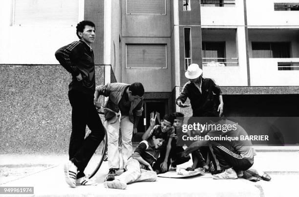 Jeunes issus de l'immigration jouant au pied de leur immeuble dans la cité des Minguettes en juillet 1981 à Vénissieux, France.