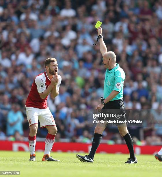 Shkodran Mustafi of Arsenal watches in disbelief as he is shown the yellow card by referee Lee Mason during the Premier League match between Arsenal...