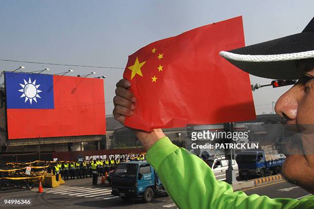 An anti-China protester holds the national flag of China during a demonstration outside of the Windsor hotel, where a fresh round of talks between...