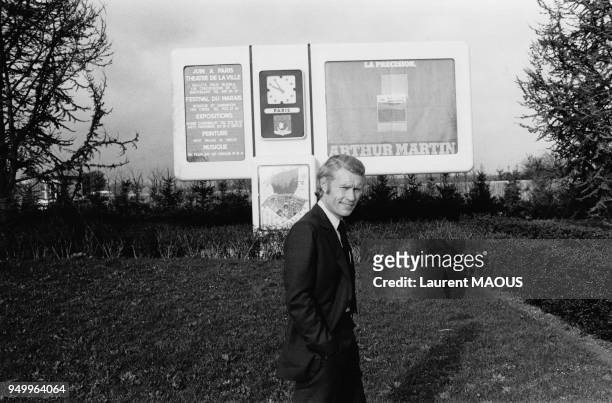Industriel Jean-Claude Decaux devant l'un de ses panneaux d'affichage à Paris, en France, le 3 mars 1977.