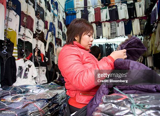 Shopper examines a jacket at a market in Hanoi, Vietnam, on Monday, Dec. 21, 2009. Vietnam's fourth-quarter GDP figures will be released on or after...