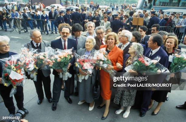 La famille Klarsfeld apportant des bouquets de fleurs pour la stèle en hommage aux enfants juifs déportés d'Izieu en mai 1987 à Lyon, France.