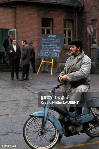Ouvrier quittant son travail sur sa mobylette en France dans les années 70. Circa 1970.