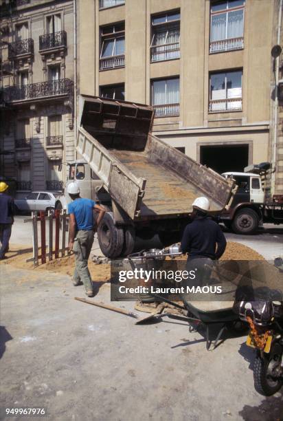 Ouvrier et camion-benne sur un chantier public à Paris dans les années 70. Circa 1970.