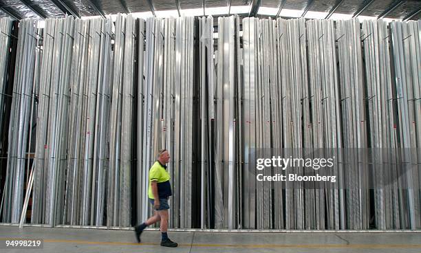 Employee Richard Harte walks past a stockpile of aluminum ladders at the Ullrich Aluminium Co. Factory in Auckland, New Zealand, on Tuesday, Dec. 22,...