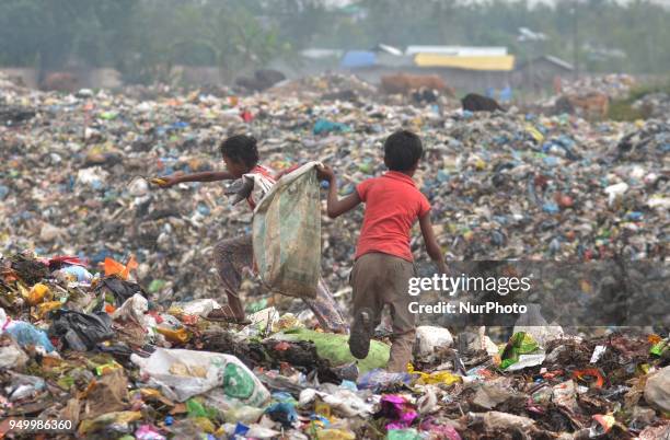 Young Indian rag picker search among piles of garbage at a dumping site on World Earth Day in Dimapur, India north eastern state of Nagaland on...