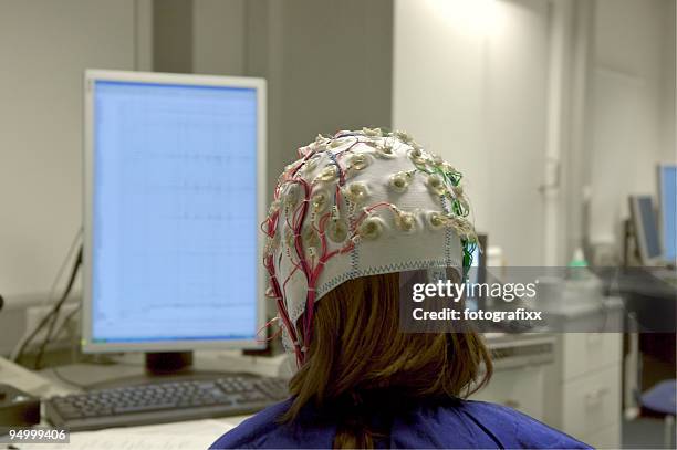 girl connected with cables for eeg in front of screen - telepathy 個照片及圖片檔