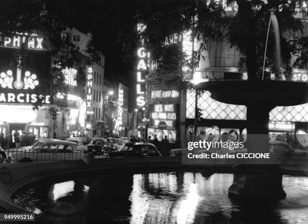 La place Pigalle et ses enseignes lumineuses, de nuit, circa 1960 a Paris, France.