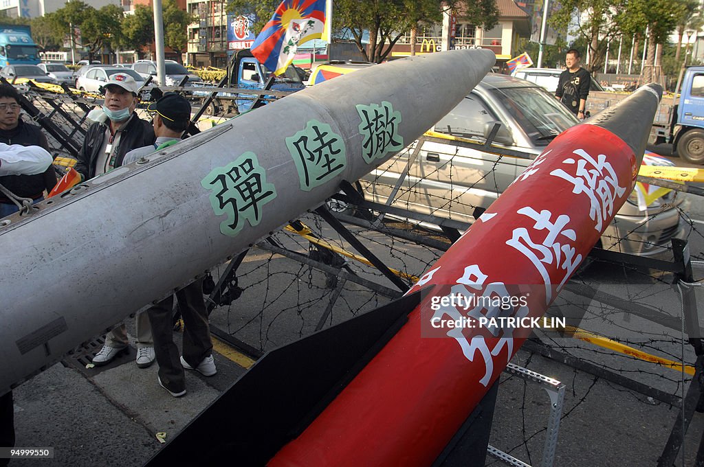 Protesters display two mock missiles to