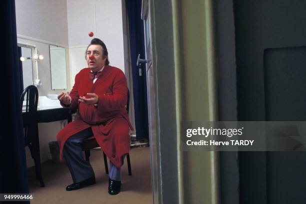 Humoriste Raymond Devos dans sa loge jonglant avec des nez de clown, circa 1980 en France.