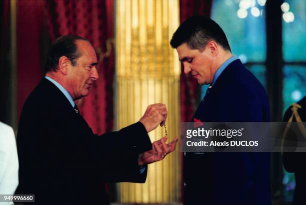 Jacques Chirac décore David Douillet, médaillé olympique français, lors d'une cérémonie dans les salons de l'Elysée le 6 novembre 2000 à Paris,...