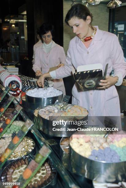 Vendeuses au rayon confiserie à l'épicerie fine Fauchon à Paris, circa 1970, à Paris, France.