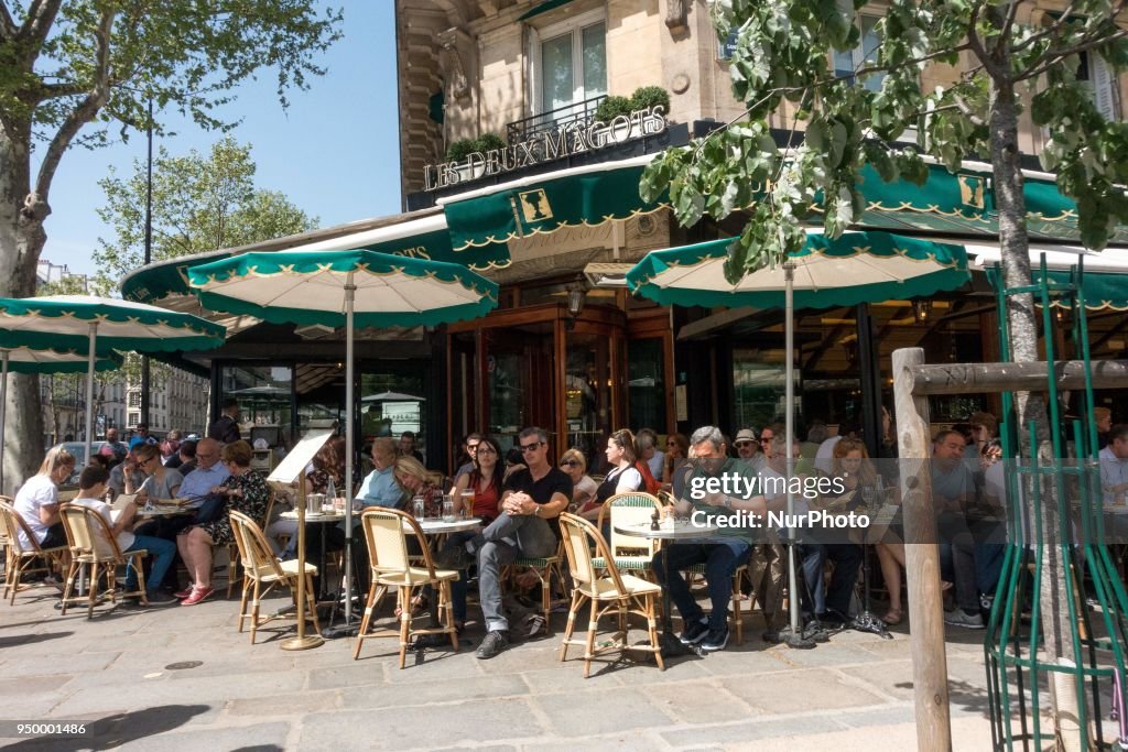 People enjoy the sun and warm spring temperatures in Paris