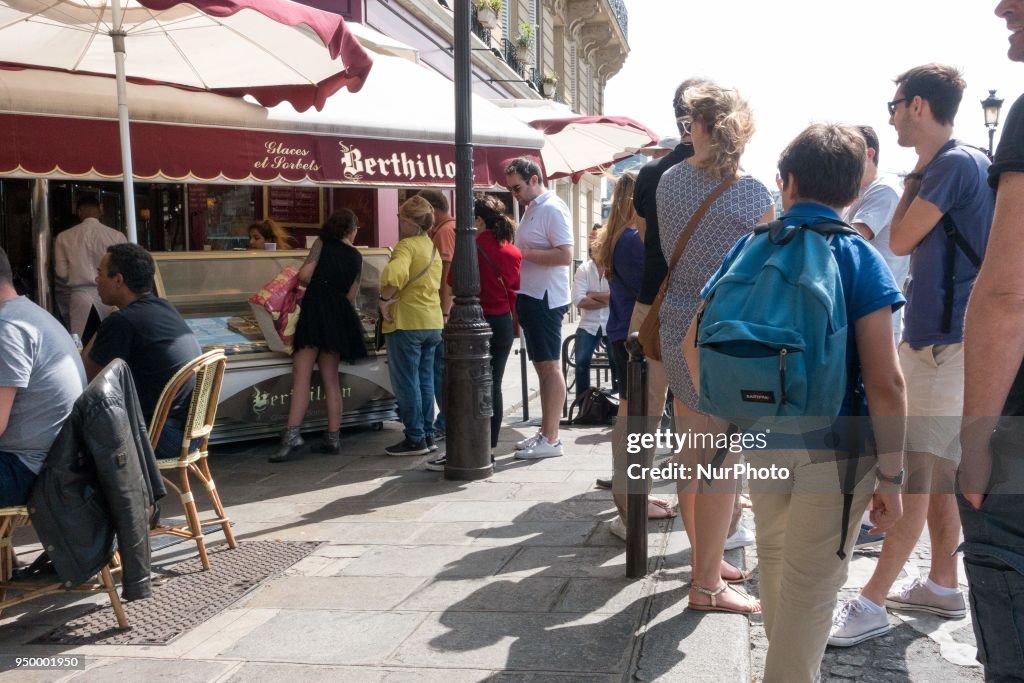 People enjoy the sun and warm spring temperatures in Paris