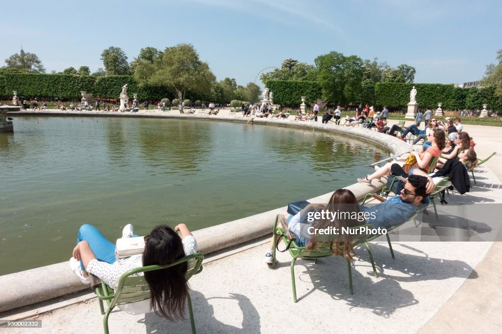 People enjoy the sun and warm spring temperatures in Paris