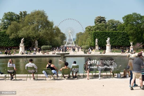 People relax on a warm weather Spring day in the Tuileries garden in Paris, on April 22, 2018.