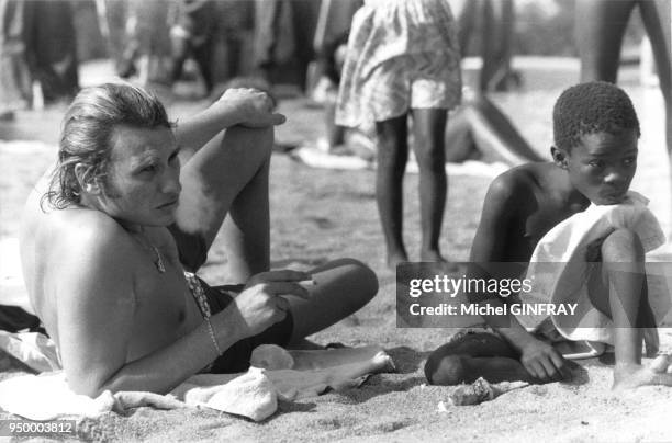 Johnny Hallyday se détend sur une plage d'Abidjan lors d'une tournée en juin 1977, Abidjan, Cote d'Ivoire.