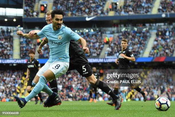 Manchester City's German midfielder Ilkay Gundogan vies with Swansea City's Dutch defender Mike van der Hoorn during the English Premier League...