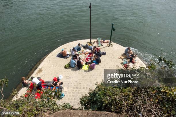 Under a blazing sun, tourists and Parisians go out to reclaim the banks of the Seine, in Paris on April 22, 2018.