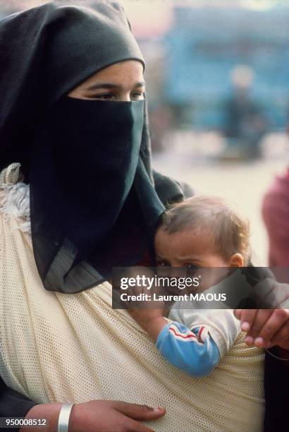 Femme marocaine en niqab avec son enfant, Maroc.