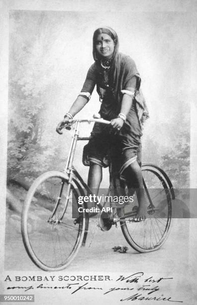 Jeune femme en sari sur une bicyclette, à Bombay en Inde.