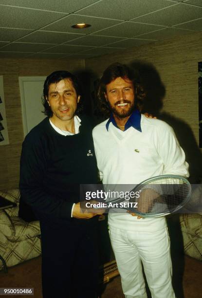 Ilie Nastase gives an Adidas "Lendl" racquet to Barry Gibb at the Hamptons, in 1982 Miami, Floride.