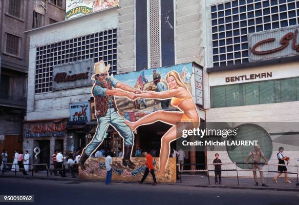 Devanture de Cinéma avec un cowboy et une femme en maillot de bain en carton dans les rues du Caire en juin 1974 en Egypte.
