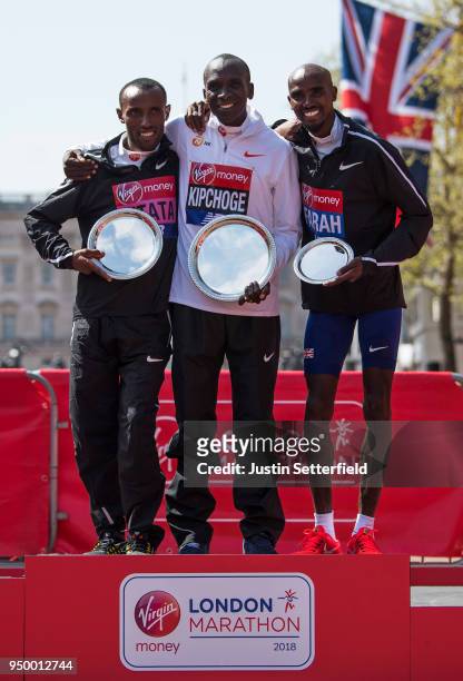 Second placed Tola Shura Kitata of Ethiopia, winner Eliud Kipchoge of Kenya and third placed Mo Farah of Great Britain pose with their trophies...