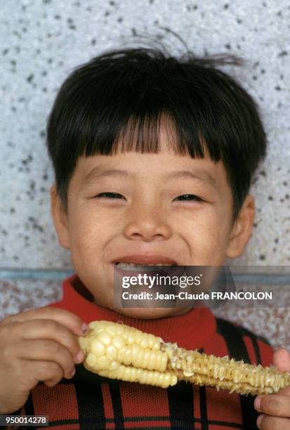 Jeune chinois entrain de manger un épi de maïs, circa 1970, Chine.