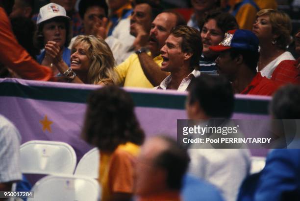 Farrah Fawcett et Ryan O'Neal spectateurs de l'epreuve de boxe lors des Jeux Olympiques de Los Angeles en aout 1984 a Los Angeles, Etats-Unis.