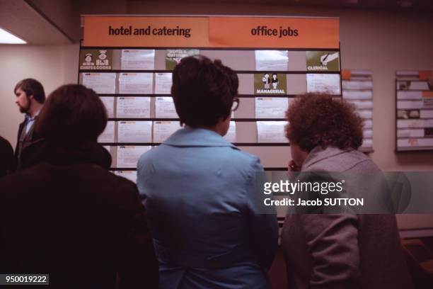 Groupe de femmes de dos regardant des annonces pour des emplois en décembre 1984 à Doncaster au Royaume-Uni.