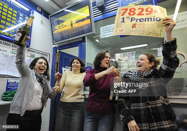 Lottery shop keepers who sold the winning ticket show the ticket number as they celebrate on December 22, 2009 in Madrid. Spain's Christmas lottery...