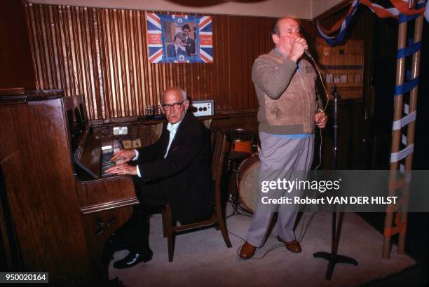 Deux hommes âgés, l'un pianiste et l'autre chanteur lors d'un concert dans un pub, en août 1981, à Londres, Royaume-Uni.