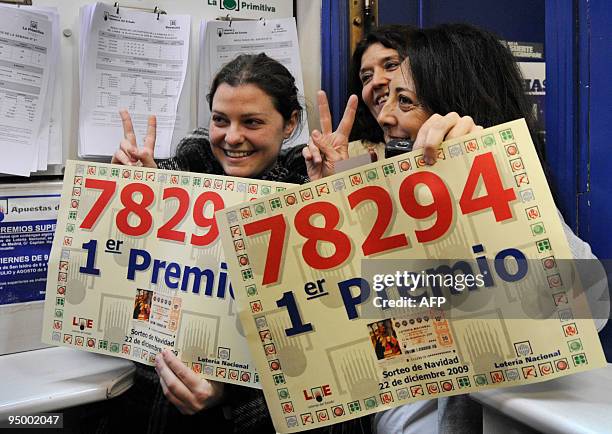 Lottery shop keepers who sold the winning ticket show the ticket number as they celebrate on December 22, 2009 in Madrid. Spain's Christmas lottery...
