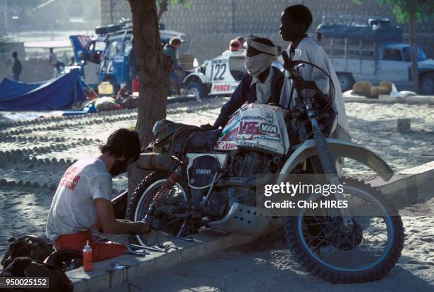 Un concurrent répare sa moto lors du Rallye Paris-Dakar en 1981 dans la région de Gao, Mali.
