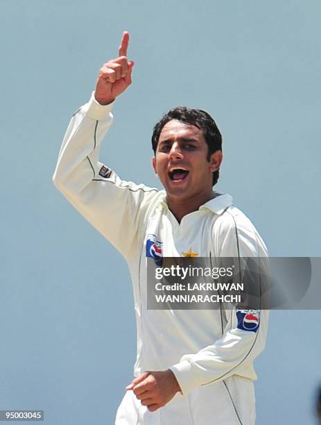 Pakistan cricketer Saeed Ajmal celebrates after the dismissal of unseen Sri Lankan cricketer Angelo Mathews during the second day of the second Test...