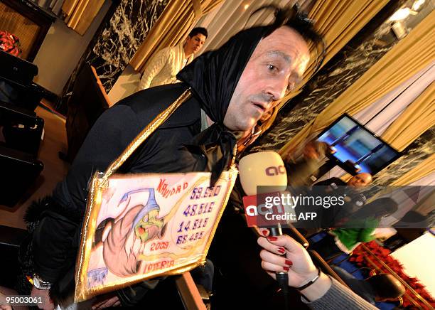 Man wearing in costume, speaks to a journalist as he takes part in the draw of the winning numbers of Spain's Christmas lottery named "El Gordo" in...