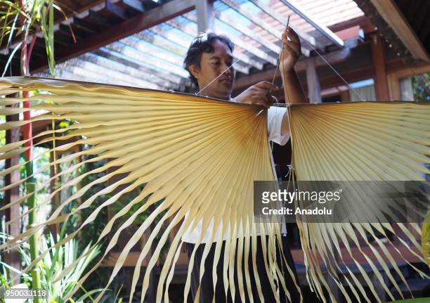Ikadek Dwi Armika makes an organic kite that made up of taep leaves, corn husk and dried fruits in Bali, Indonesia on April 21, 2018. Ikadek said...