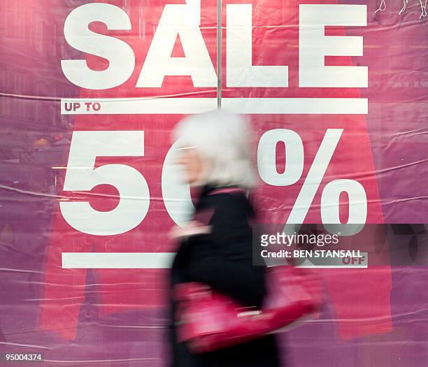 Woman walks past a pre-christmas sale sign in a department store in central London, on December 22, 2009. Britain remains the last major economy in...