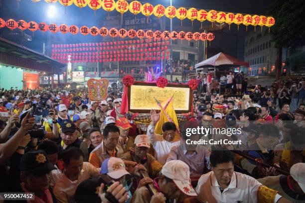 Pilgrims carry a sedan chair holding a statue of the goddess Mazu as they approach Jenn Lann Temple on the final day of the nine day Mazu pilgrimage,...