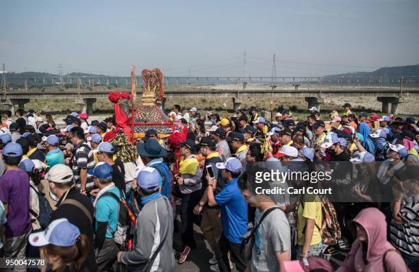 Pilgrims carry a sedan chair holding a statue of the goddess Mazu as they approach Jenn Lann Temple on the final day of the nine day Mazu pilgrimage,...