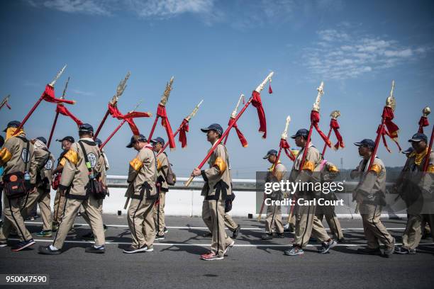 Pilgrims walk ahead of a sedan chair holding a statue of the goddess Mazu as they approach Jenn Lann Temple on the final day of the nine day Mazu...