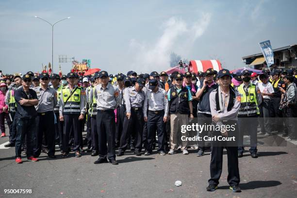 Police officers wait to greet a statue of the goddess Mazu as it approaches Jenn Lann Temple on the final day of the nine day Mazu pilgrimage, on...